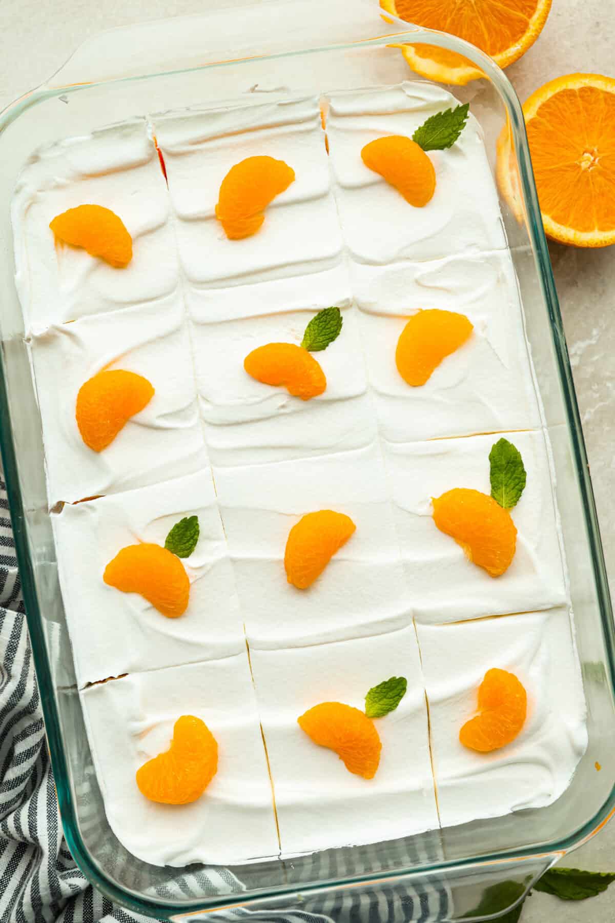 Orange creamsicle lush is sunshine in dessert form! With creamy orange layers, a buttery golden Oreo crust, and bright fresh citrus flavor, this easy no-bake dessert is a fun twist on my popular Lemon Lush that’s perfect for summer. Orange creamsicle lush garnished with mandarin oranges and mint leaves.