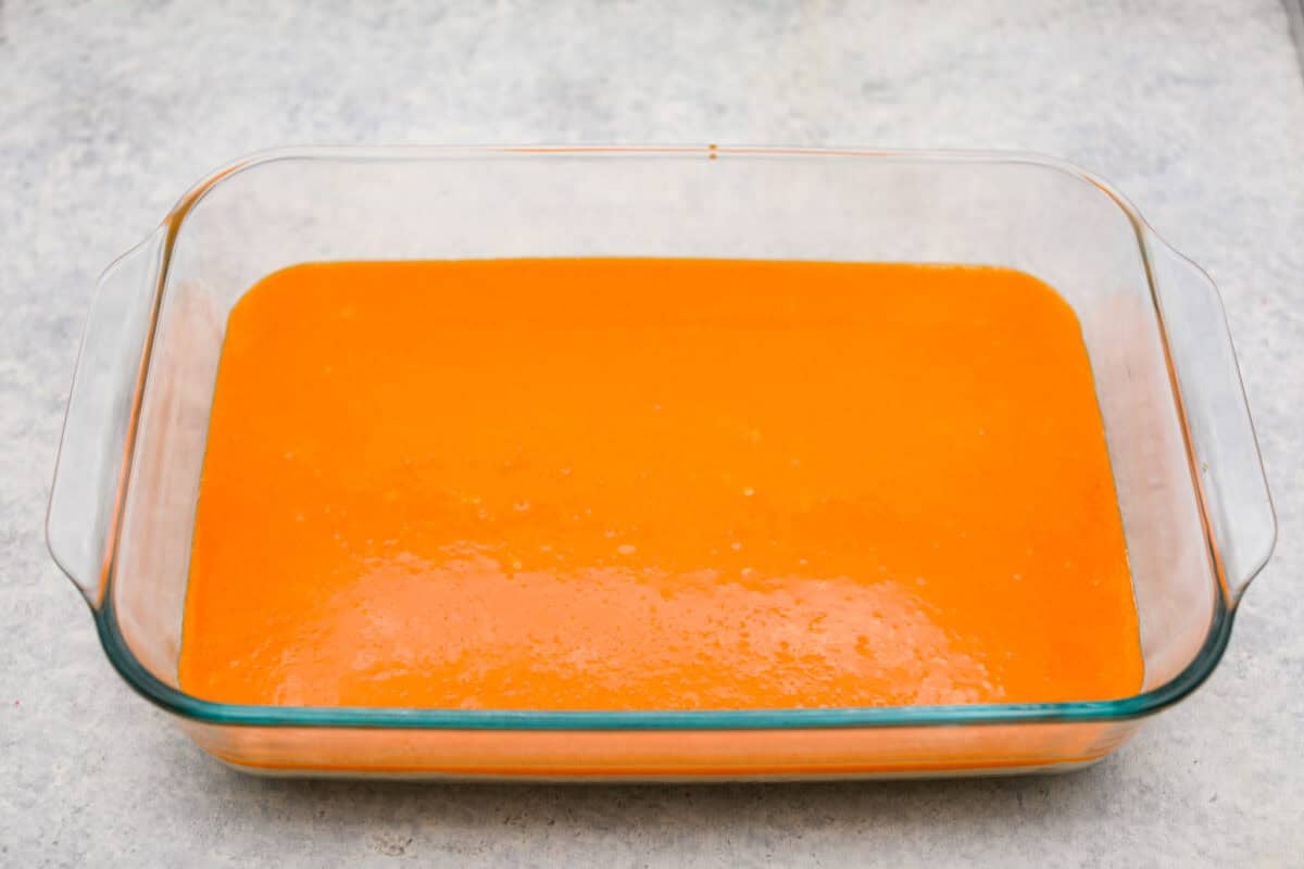 Orange creamsicle lush is sunshine in dessert form! With creamy orange layers, a buttery golden Oreo crust, and bright fresh citrus flavor, this easy no-bake dessert is a fun twist on my popular Lemon Lush that’s perfect for summer. Orange creamsicle lush mixture on top of the cream cheese layer.