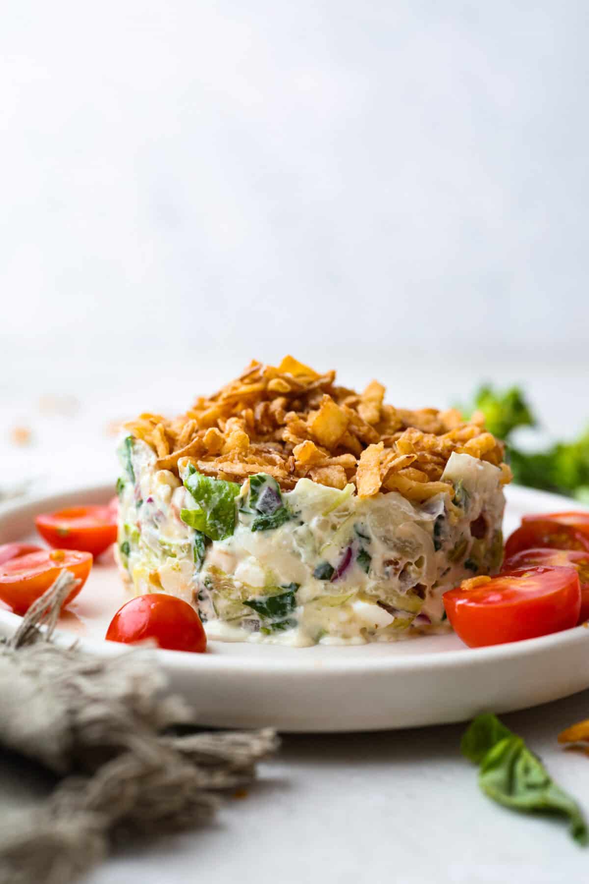 Ruth's Chris chopped salad is a steakhouse legend, and now you can make it at home for a fraction of the price. Crisp greens, smoky bacon, bold blue cheese, and a tangy lemon basil dressing come together in one showstopping bowl that tastes just like the real thing. Classic Ruth's Christ salad on a plate in a ring shape like how it's served at the restaurant.