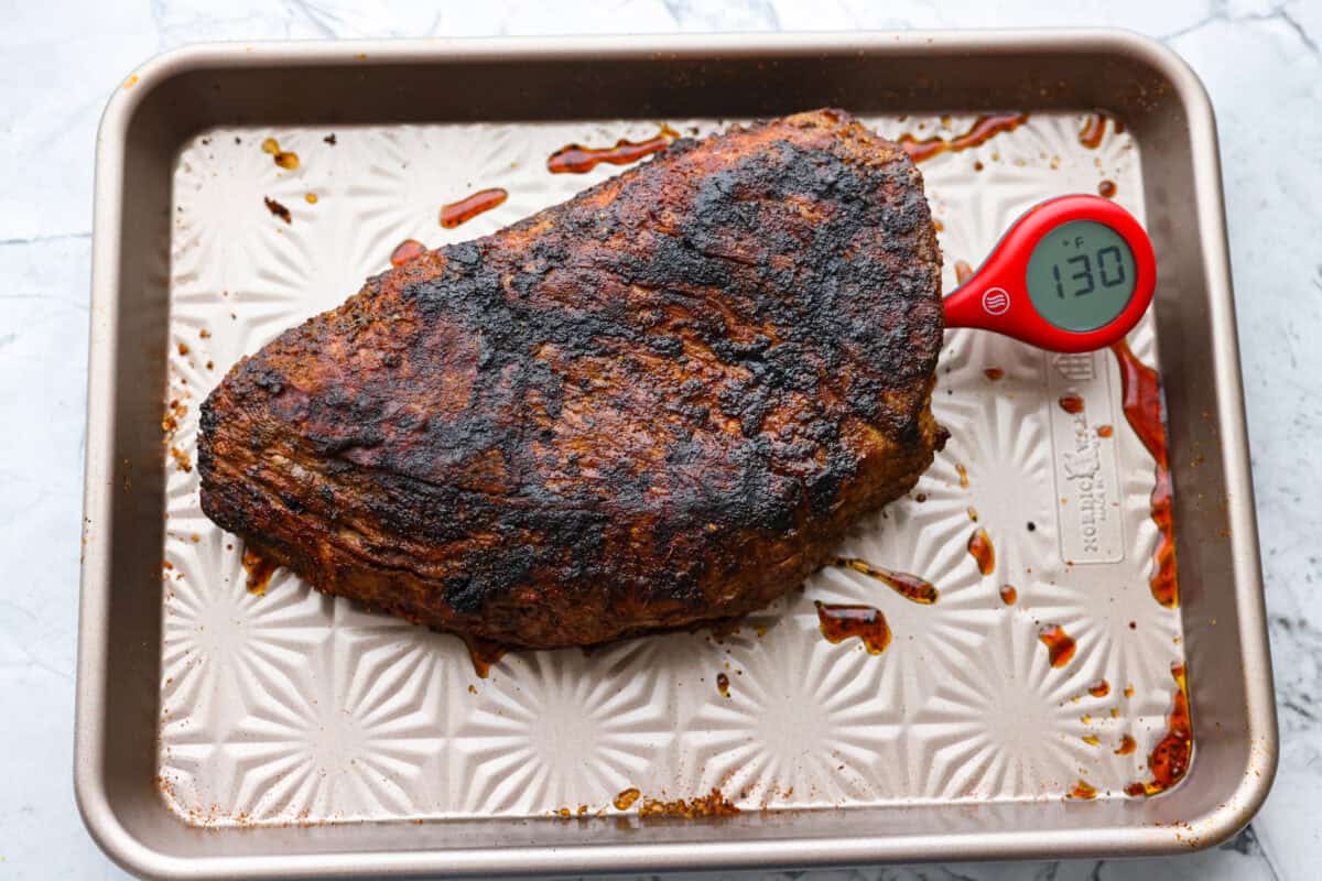 Santa Maria grilled tri-tip is juicy, smoky, and loaded with bold flavor from a delicious spice rub. Grilled until perfectly tender with a gorgeous crust, it’s an easy recipe that’s always a hit at cookouts and summer dinners. Instant read thermometer checking the temperature of the cooked meat.