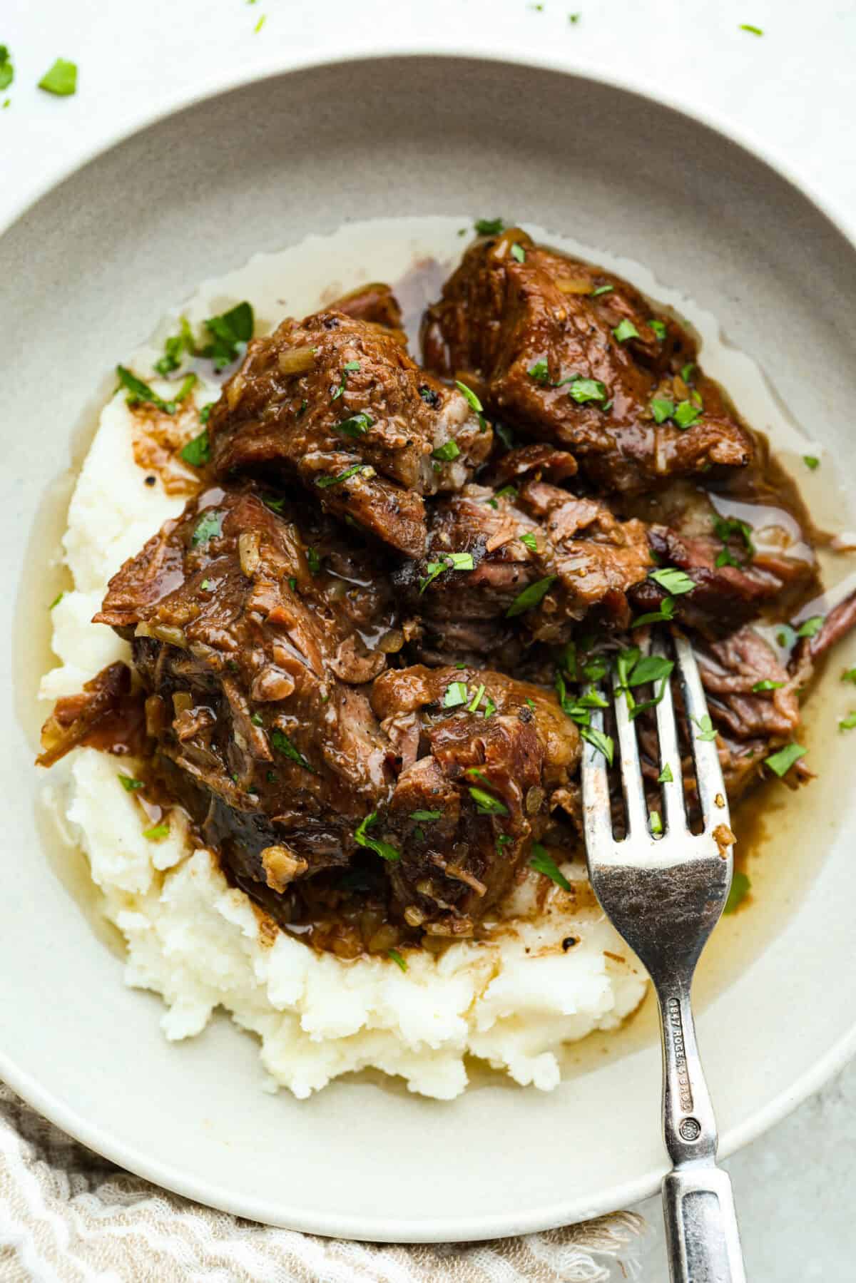 Cooks the chuck roast low and slow until it is tender, j Plate of mashed potatoes topped with 3 ingredient butter beef.