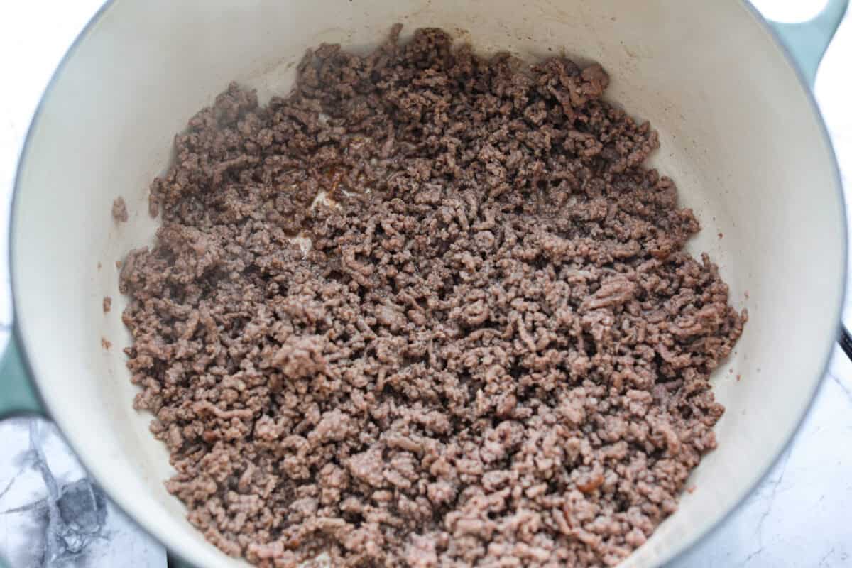 Move over spaghetti and meat sauce, dirty spaghetti is here to spice up dinner! Inspired by Cajun dirty rice, it's a one-pot recipe loaded with seasoned beef, tender vegetables, and bold flavors in every bite. Ground beef cooking in a pot.