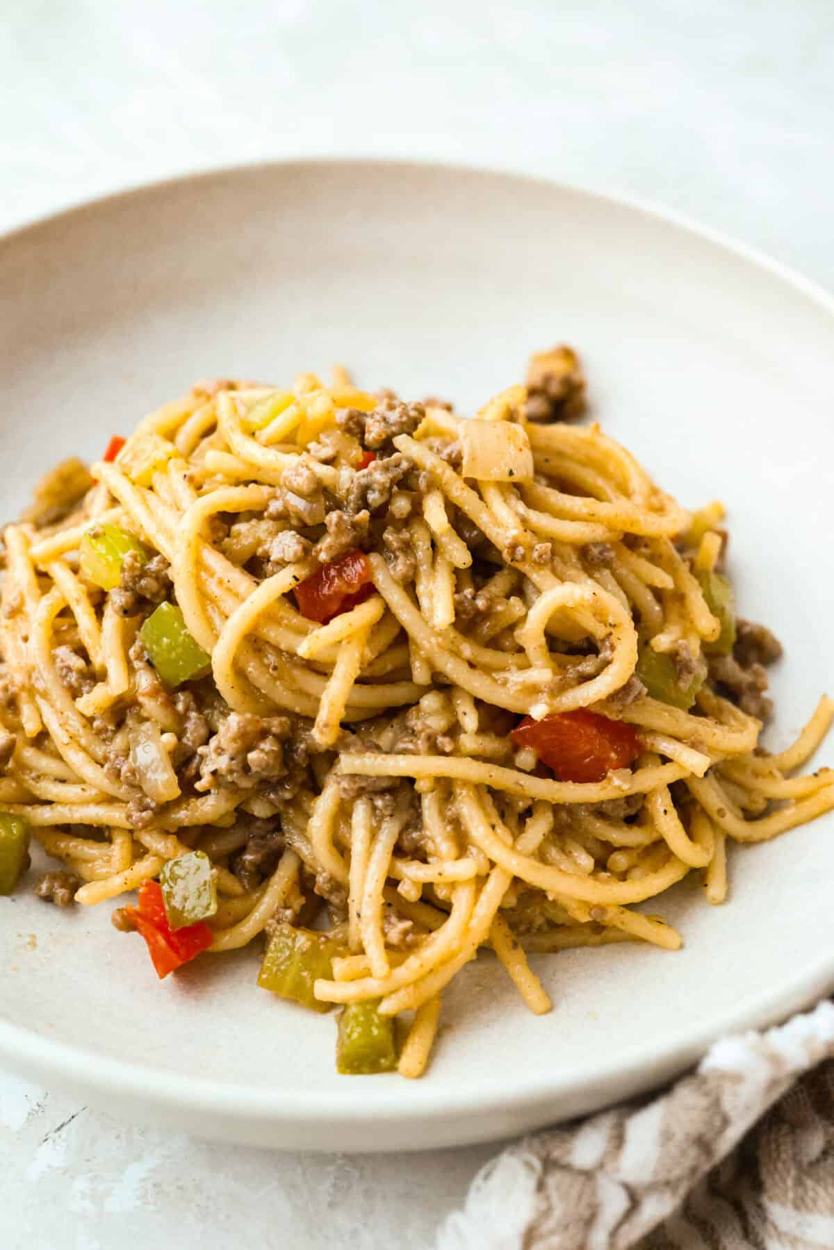 Move over spaghetti and meat sauce, dirty spaghetti is here to spice up dinner! Inspired by Cajun dirty rice, it's a one-pot recipe loaded with seasoned beef, tender vegetables, and bold flavors in every bite. Serving of dirty spaghetti on a plate.