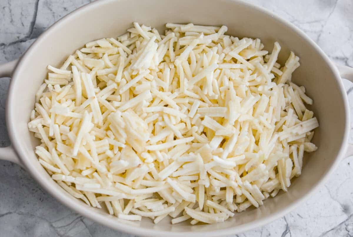 This farmer's casserole is my answer to summer mornings when the kids want cereal again, but I want them to eat something that will actually keep them full. It’s packed with protein, and it's easy to customize with fresh garden veggies. Hash browns in the bottom of a baking dish.