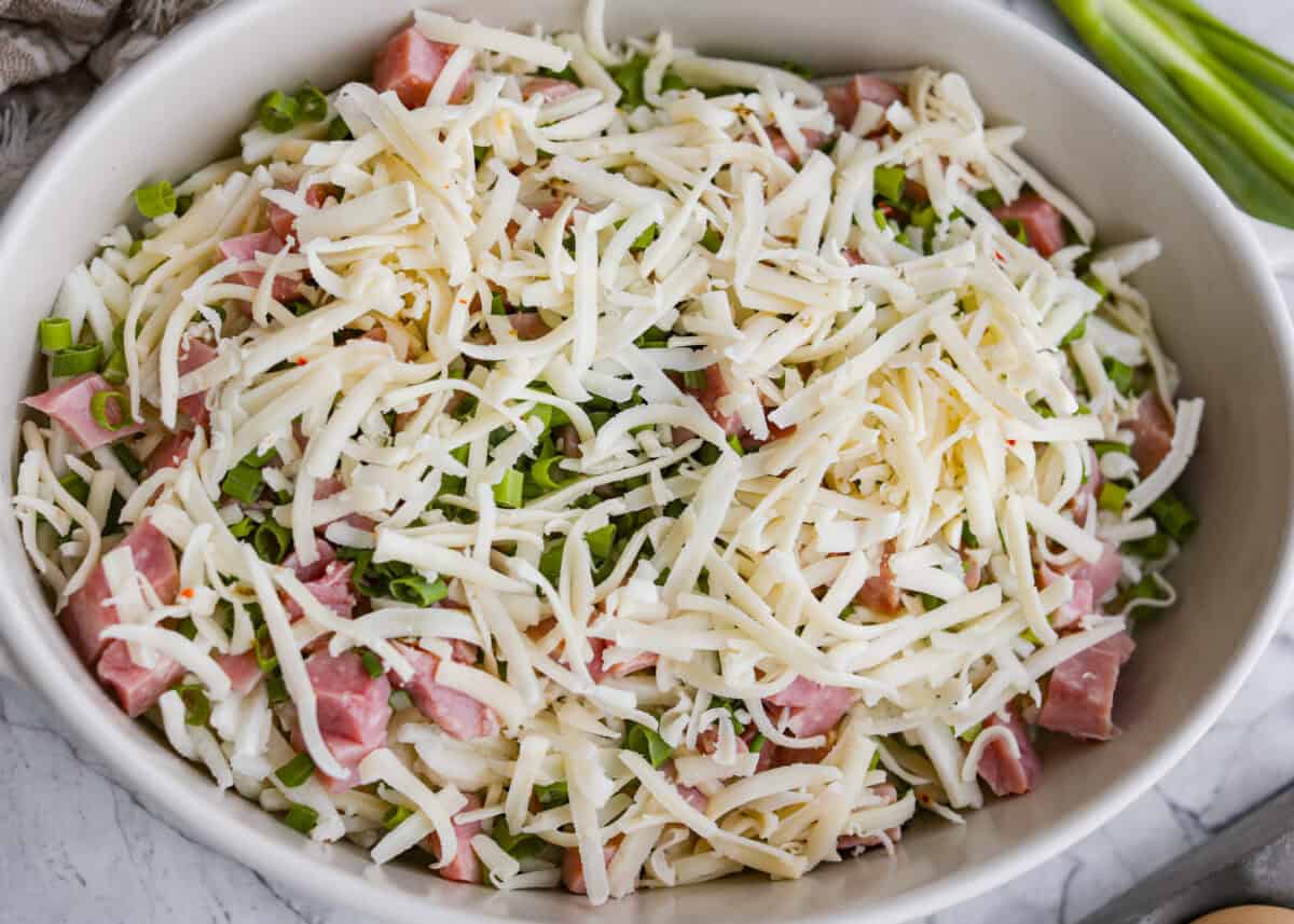 This farmer's casserole is my answer to summer mornings when the kids want cereal again, but I want them to eat something that will actually keep them full. It’s packed with protein, and it's easy to customize with fresh garden veggies. Ham, green onions, and cheese added to the baking dish.