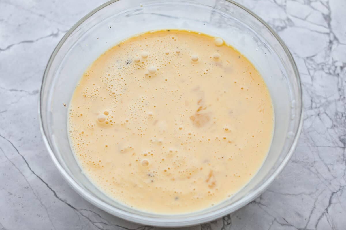 This farmer's casserole is my answer to summer mornings when the kids want cereal again, but I want them to eat something that will actually keep them full. It’s packed with protein, and it's easy to customize with fresh garden veggies. Egg mixture all whisked together in a bowl.