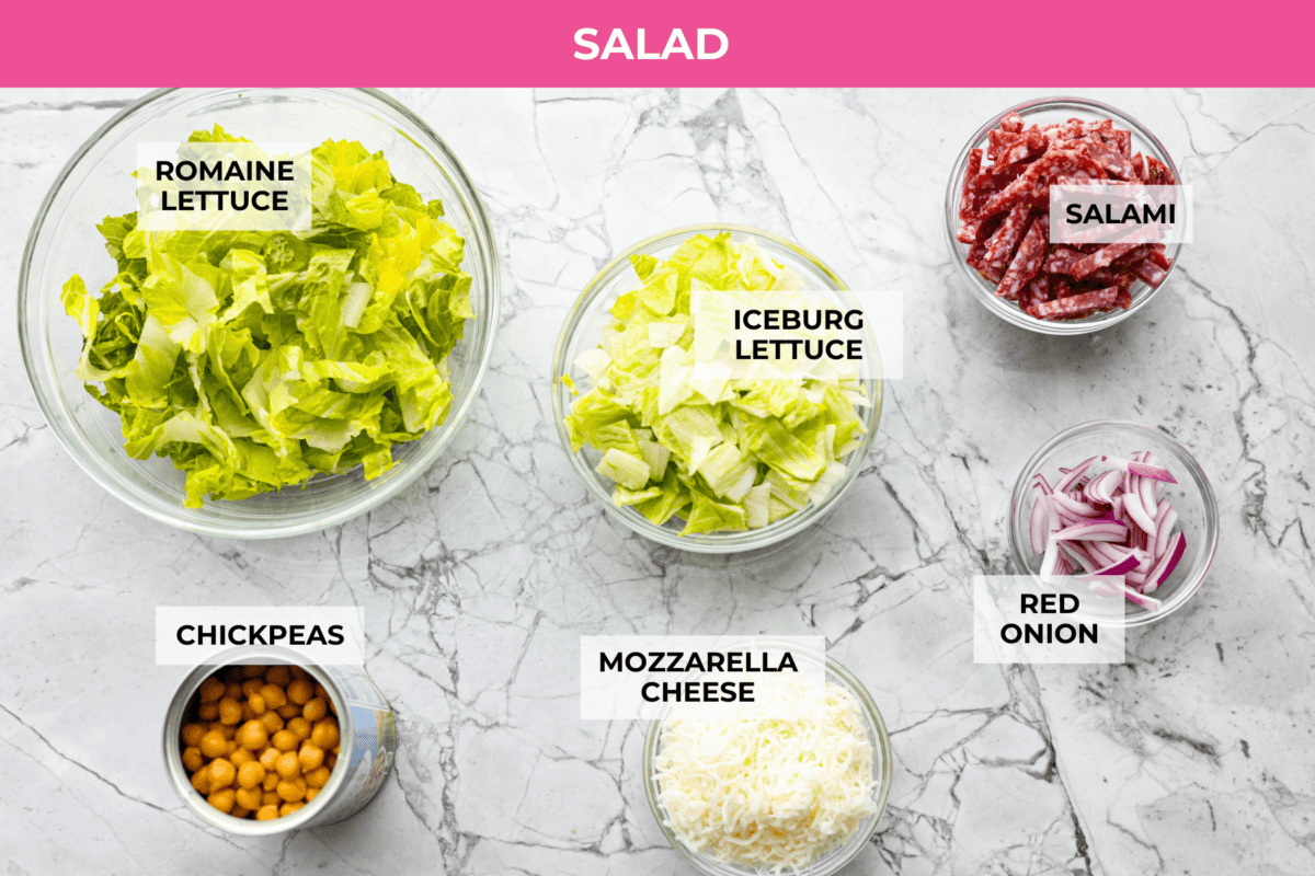 This copycat La Scala Salad is the famous Italian chopped salad from Beverly Hills that Kim Kardashian is rumored to love. It’s fresh, crunchy, and packed with chickpeas, salami, mozzarella, and zesty red wine vinaigrette. Overhead shot of labeled la scala salad ingredients.