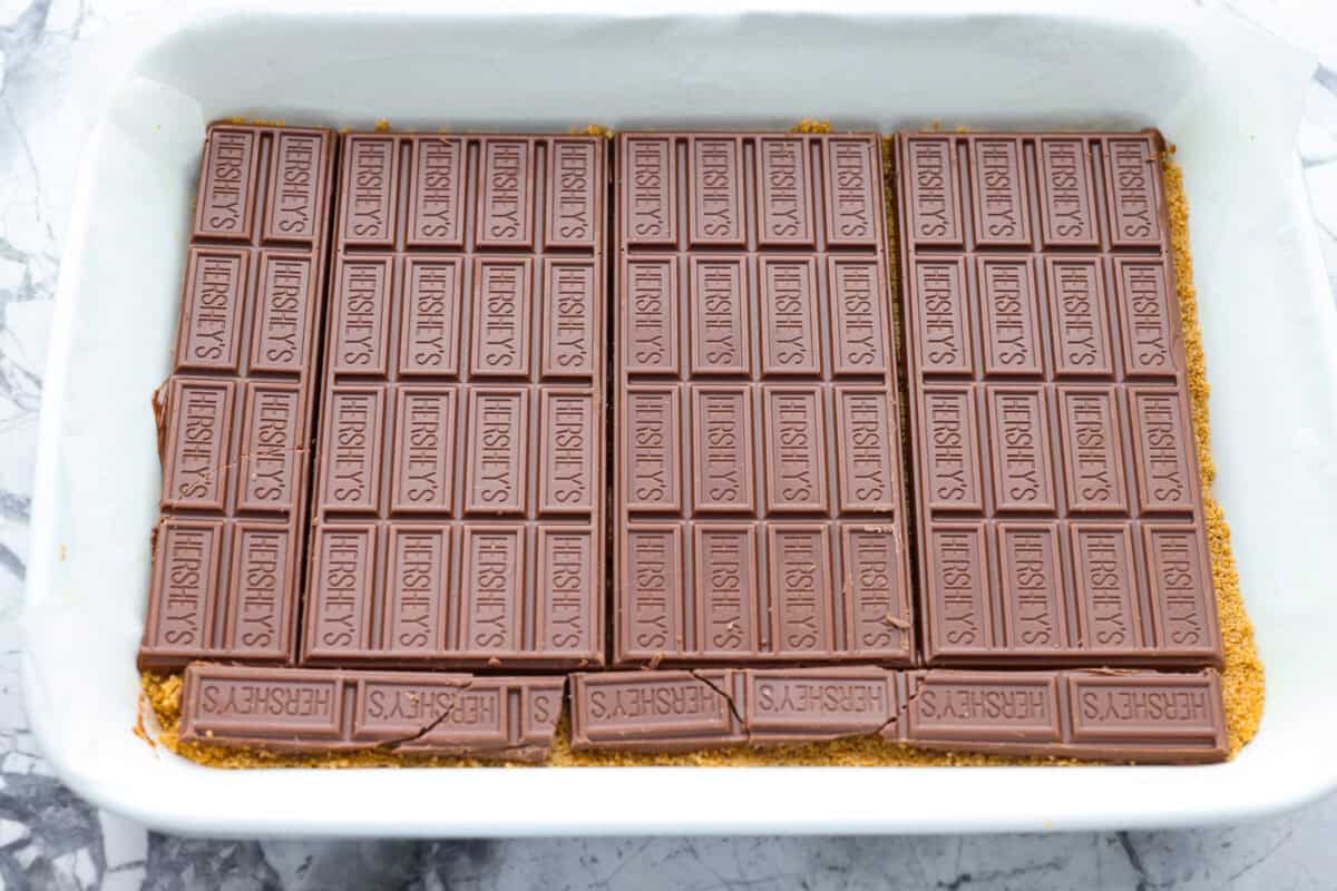 Remember the Starbucks s'mores bars everyone was obsessed with? They're back in homemade form! These easy bars have a buttery graham cracker crust, melty chocolate, and toasted marshmallows for the ultimate no-campfire-required treat. Chocolate bars added to the top of the graham cracker crust.