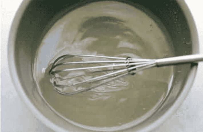 Whisking water, sugar, and cornstarch to create a glaze. 