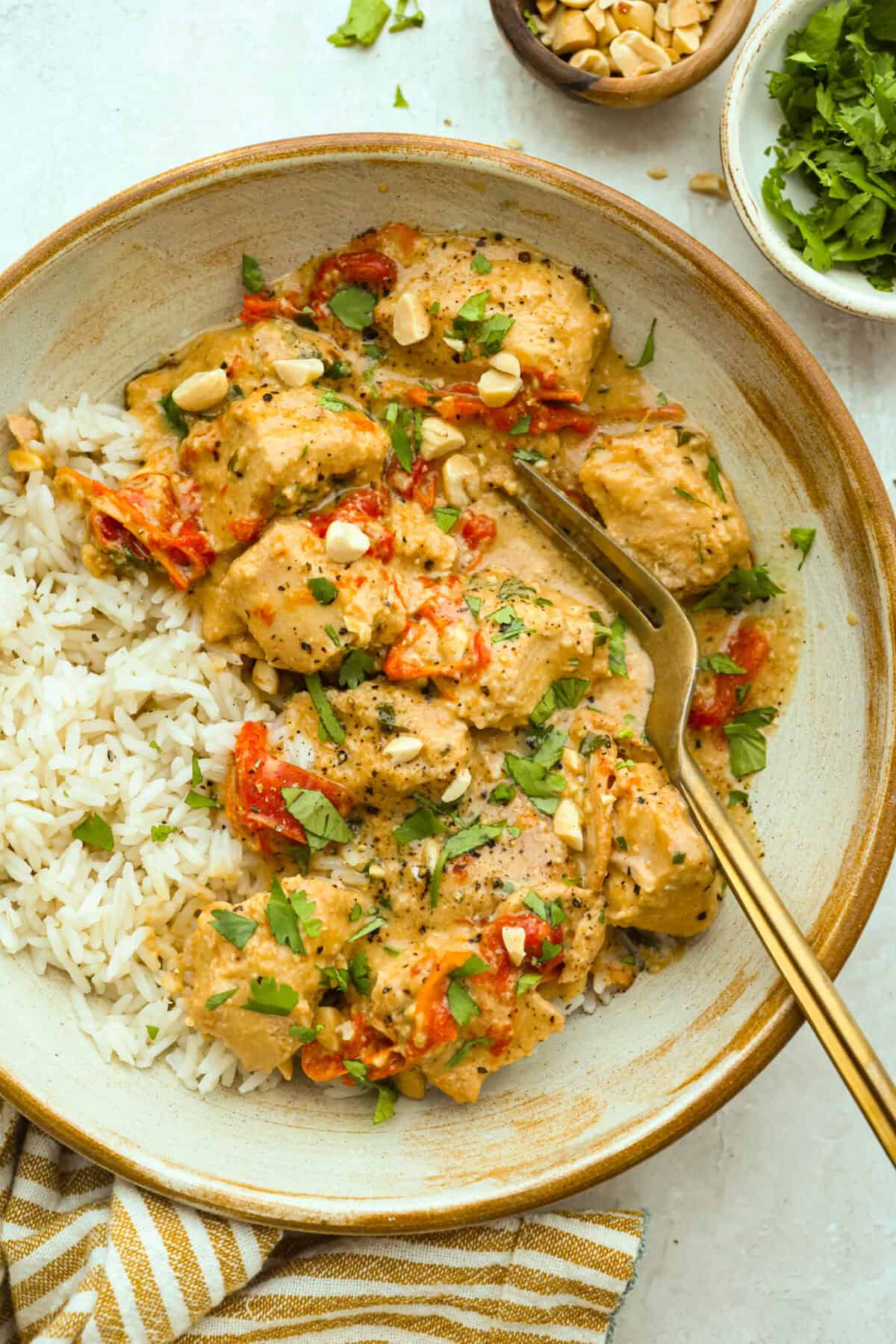 You asked, I listened! This slow cooker Thai peanut chicken got a serious glow-up! The sauce is creamy, savory, a little sweet, and packed with peanut coconut flavor. I’d drink it with a straw if that were socially acceptable, but spooning it over rice, noodles or adding it to lettuce wraps is probably the better dinner move. Plate of slow cooker Thai peanut chicken over a bed of rice.