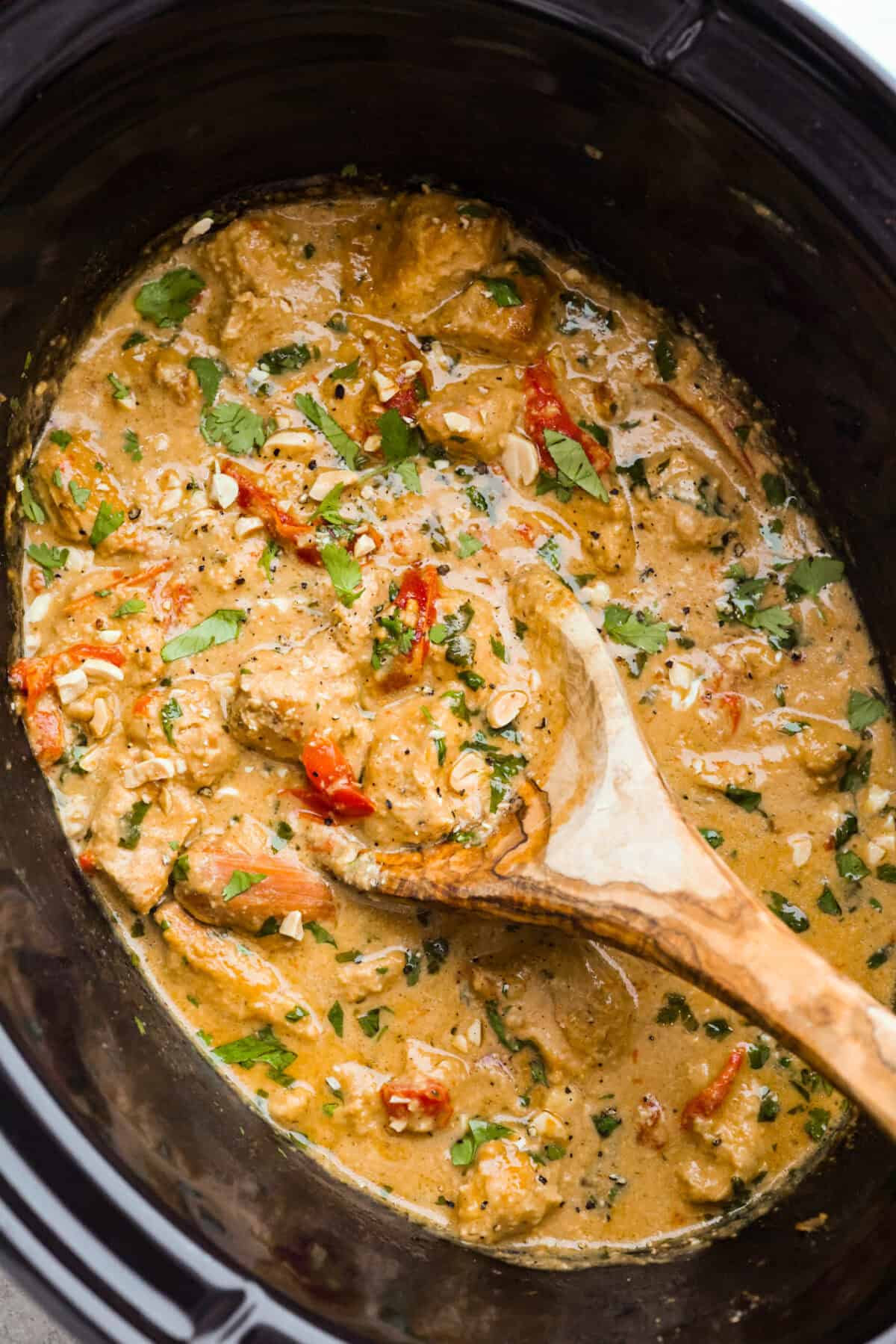 You asked, I listened! This slow cooker Thai peanut chicken got a serious glow-up! The sauce is creamy, savory, a little sweet, and packed with peanut coconut flavor. I’d drink it with a straw if that were socially acceptable, but spooning it over rice, noodles or adding it to lettuce wraps is probably the better dinner move. Slow cooker Thai Peanut chicken in a crockpot.