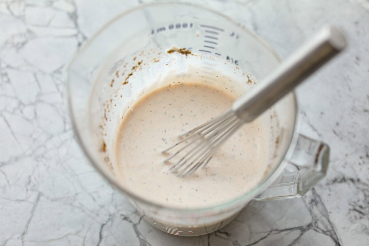 If you're a fan of deli sandwiches, you will love this sub in a tub dip! Made with deli meats, cheese, crisp veggies, and a creamy tangy dressing, it tastes just like your favorite sandwich shop sub in dip form! Dressing ingredients all whisked together in a pourable container.