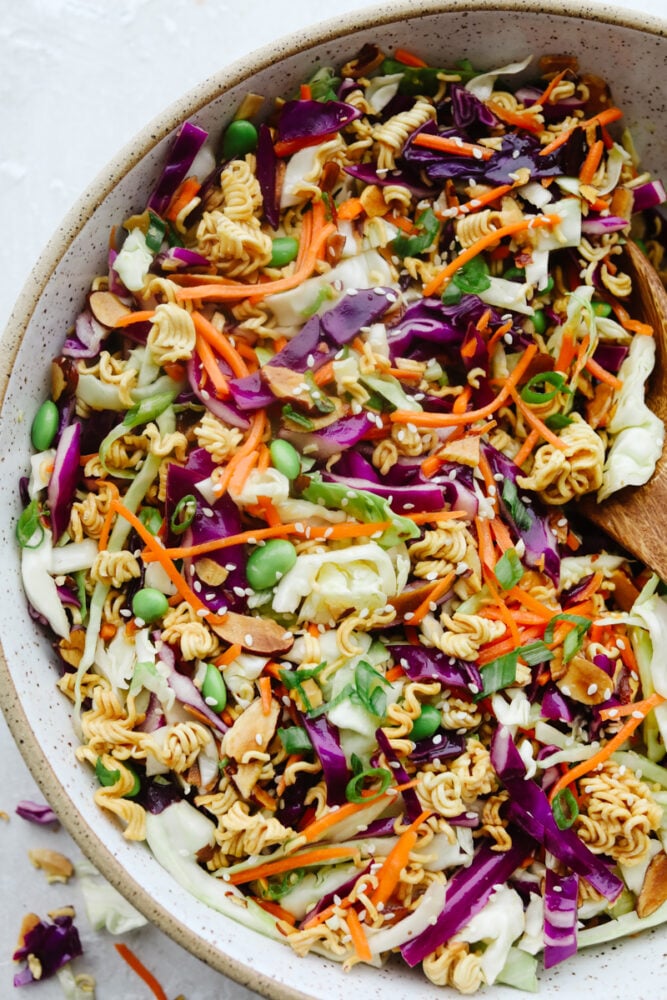 Asian ramen salad is colorful, crunchy, and packed with fresh flavor! It’s made with crisp cabbage, vegetables, toasted ramen noodles, almonds, and a sweet and savory homemade dressing. A bowl of colorful Asian Ramen salad.