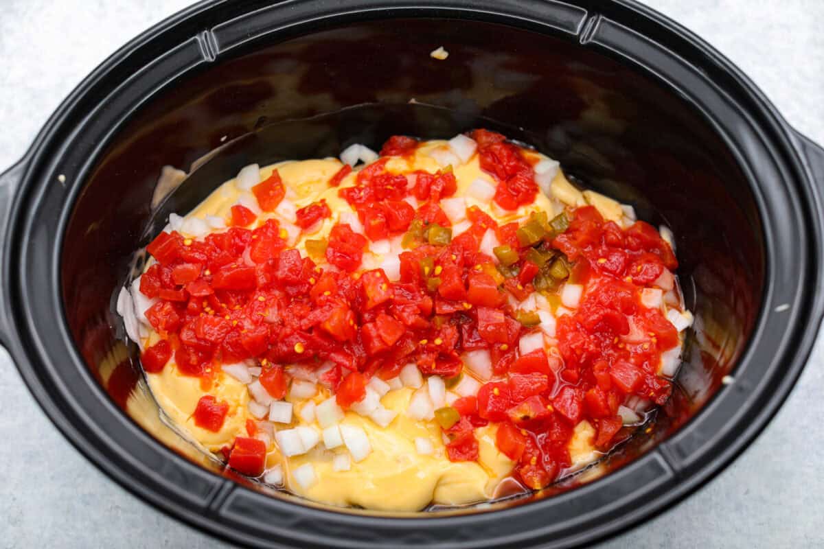 This crockpot chicken spaghetti will have everyone running to the dinner table! The slow cooker does the work while the chicken becomes tender and flavorful, then it's tossed with spaghetti, melty cheese, and a creamy sauce. Sauce ingredients added to the crockpot.