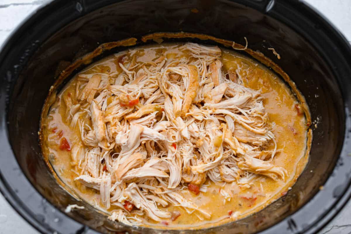 This crockpot chicken spaghetti will have everyone running to the dinner table! The slow cooker does the work while the chicken becomes tender and flavorful, then it's tossed with spaghetti, melty cheese, and a creamy sauce. Cooked chicken shredded in the sauce.