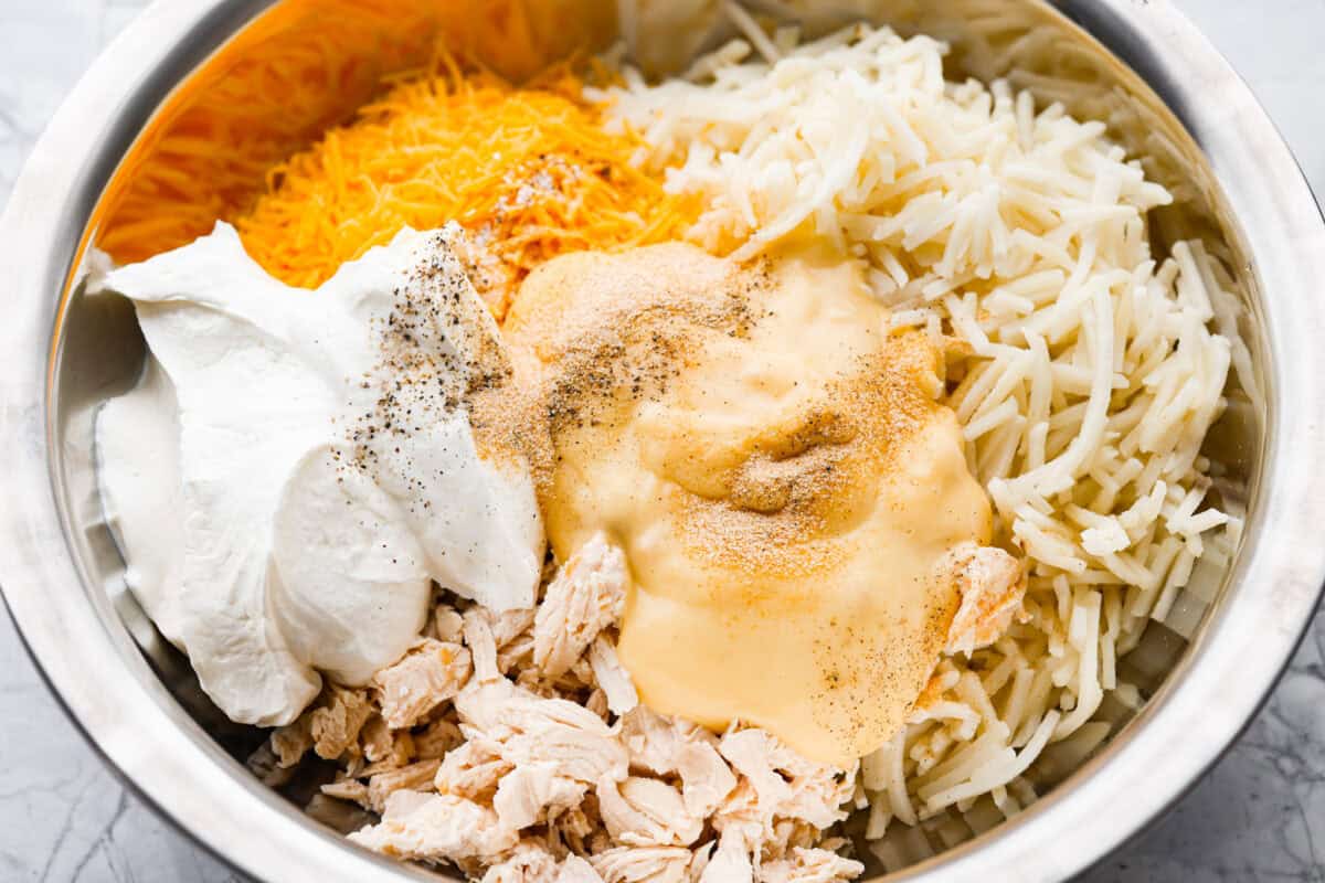 My funeral potato and chicken casserole turns the classic cheesy side dish into a complete dinner. It’s creamy, comforting, and packed with tender chicken, potatoes, and plenty of cheese. Casserole ingredients added to a mixing bowl.