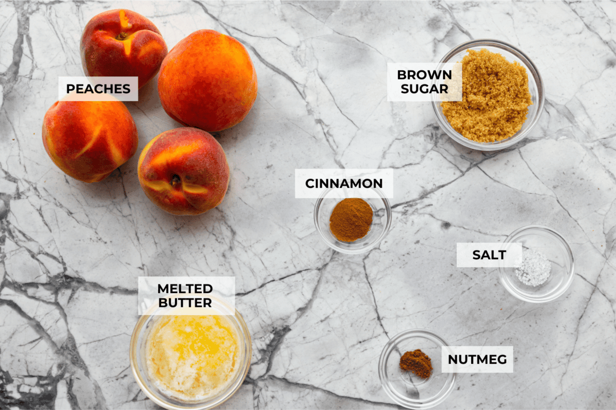 Grilled peaches are one of my favorite ways to turn ripe summer fruit into an easy dessert. The grill brings out their natural sweetness and adds just a little smoky flavor. Serve them warm with vanilla ice cream for a simple treat that feels extra special. Overhead shot of labeled ingredients.