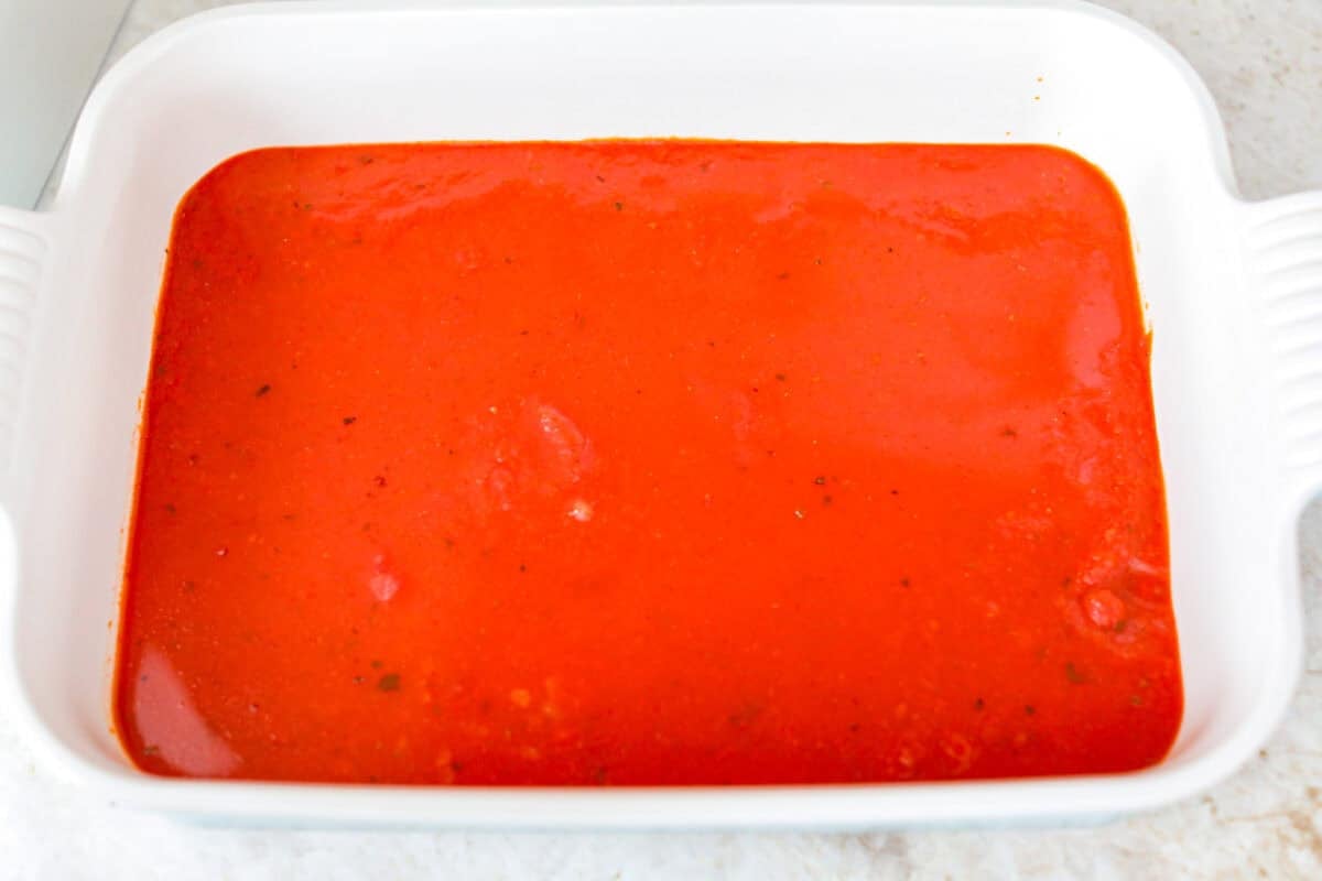 Want lasagna but absolutely cannot deal with all that layering tonight? Let me help you. This lazy meatball lasagna is cheesy, cozy, ridiculously easy, and exactly the kind of dinner we need on a busy night. Marinara sauce poured into the bottom of the baking dish.