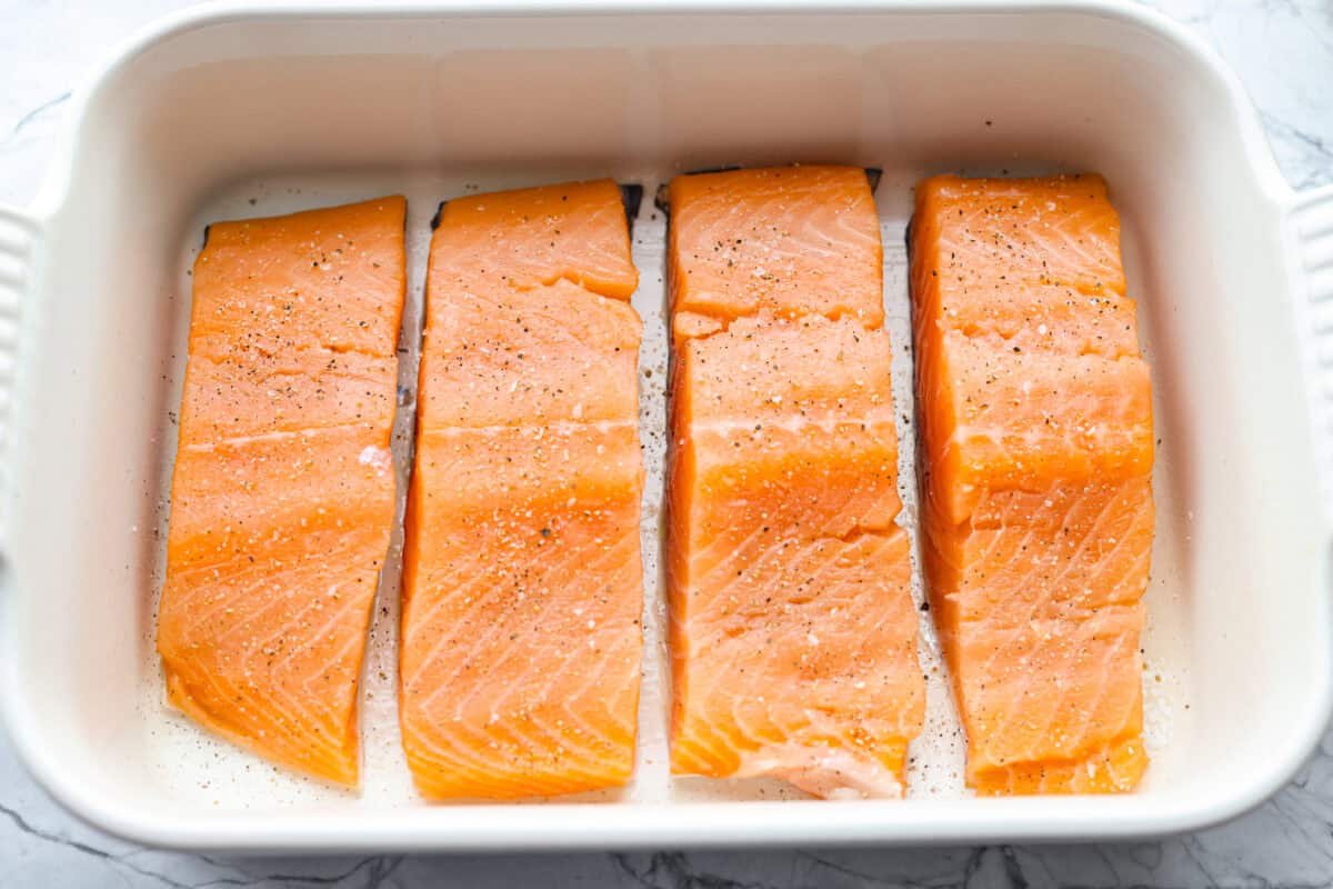 Seasoned salmon filets in a baking dish. 
