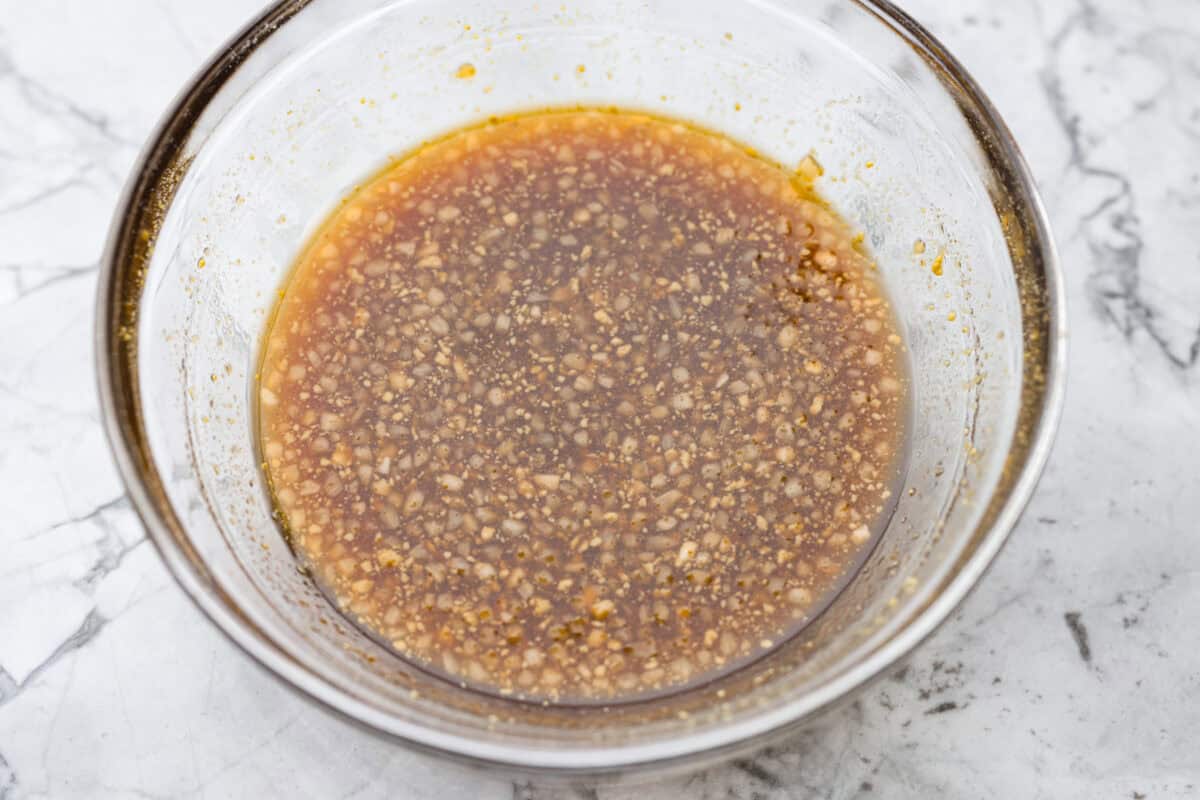 Maple glaze sauce ingredients whisked together in a bowl. 