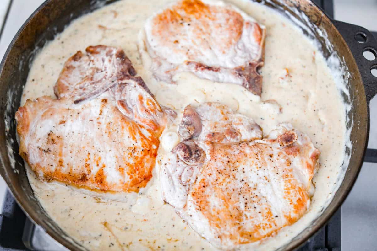Marry Me pork chops are the kind of dinner that earns its name! Tender pork chops are simmered in a rich, creamy Parmesan sauce with garlic, Italian herbs, and sweet, tangy sun-dried tomatoes. One bite and you’ll get why they’re worth proposing over. Seared pork chops added back into the sauce to simmer and finish cooking.