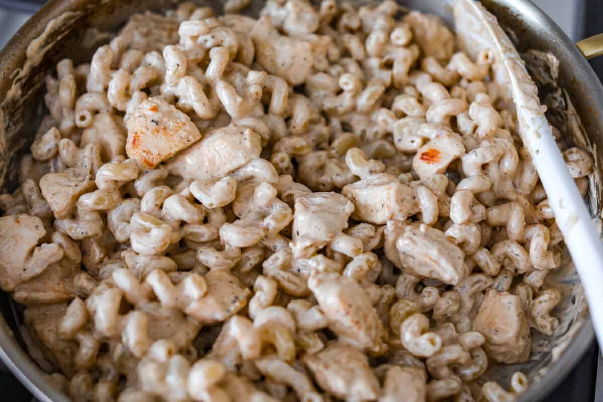 Chicken Caesar pasta is the kind of dinner you’ll want on repeat. You loved my Caesar Chicken Bake, so I turned those same creamy, savory flavors into an easy skillet pasta! It’s cozy, cheesy, and topped with crunchy croutons. Chicken and pasta added to the skillet and stirred together.