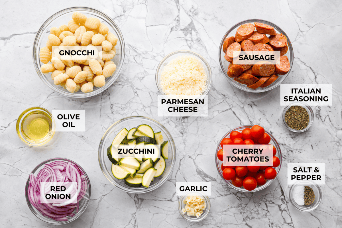This sheet pan gnocchi is about as easy as dinner gets! Everything goes onto one pan with olive oil and Italian seasoning, then roasts until the gnocchi is crispy and the veggies are tender. Finish it with Parmesan and dig in! Overhead shot of labeled ingredients.