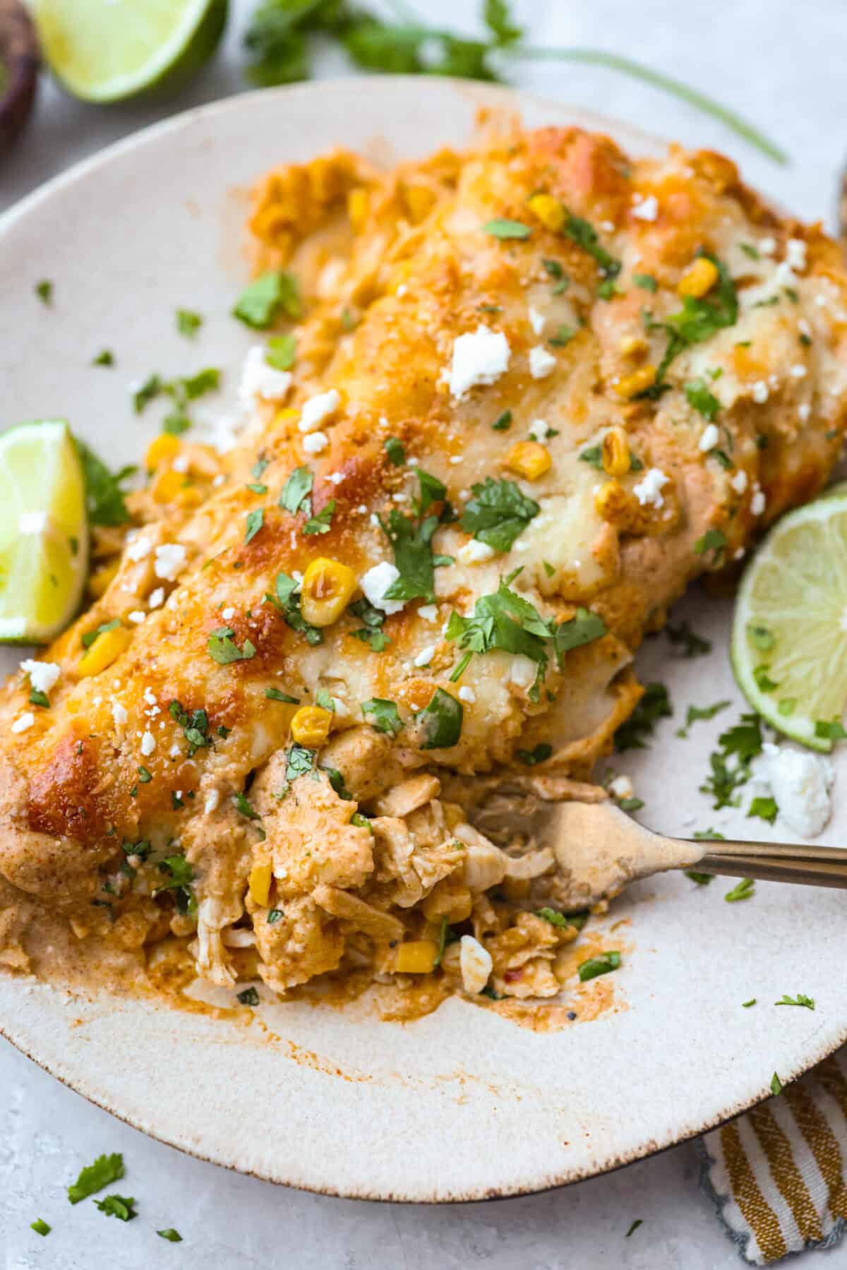 These street corn chicken enchiladas are creamy, cheesy, and packed with zesty flavor. An easy 40-minute dinner the whole family will love. Plated street corn enchiladas.