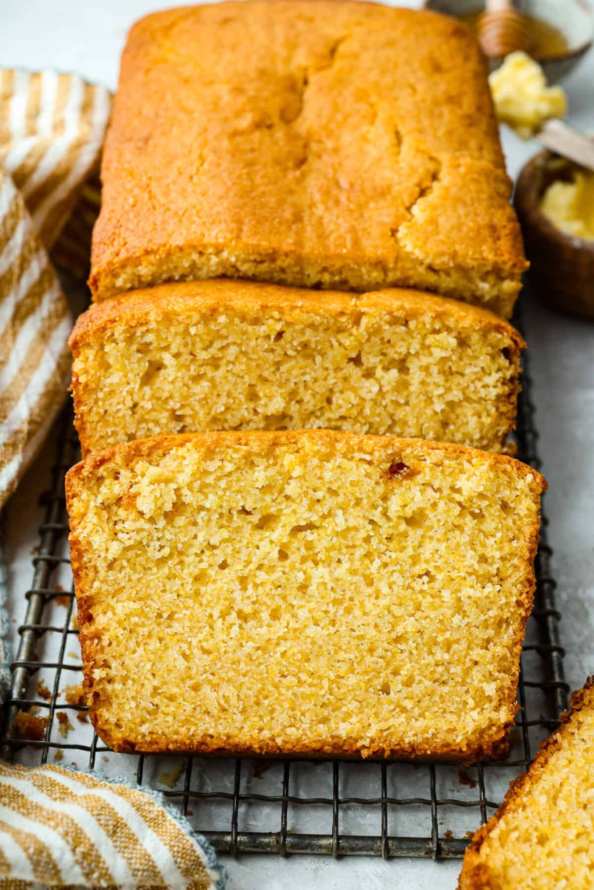 This cornbread loaf is soft, buttery, and just sweet enough, with crisp golden edges and a tender crumb. Baking it in a loaf pan gives classic cornbread a fun twist that’s easy to slice and serve with chili, stew, or your favorite comfort food. Cornbread loaf with a couple of slices cut out of it.