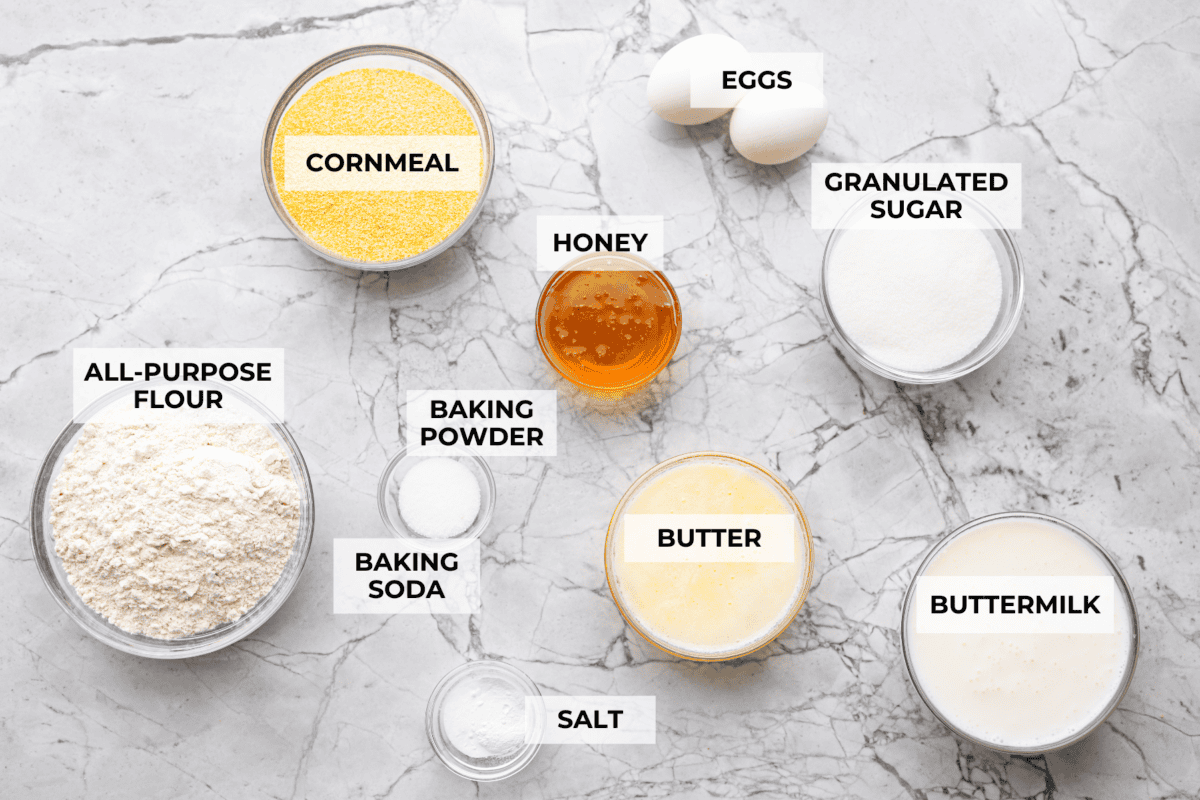This cornbread loaf is soft, buttery, and just sweet enough, with crisp golden edges and a tender crumb. Baking it in a loaf pan gives classic cornbread a fun twist that’s easy to slice and serve with chili, stew, or your favorite comfort food. Overhead shot of labeled cornbread loaf ingredients.