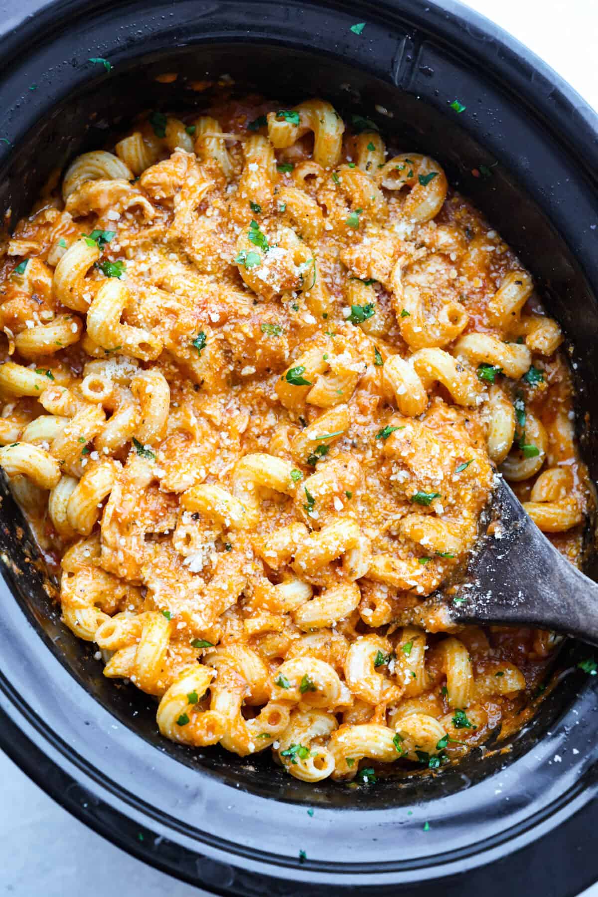 Crockpot creamy chicken pasta is the kind of dinner I need on a busy weeknight! Tender chicken cooks all day in a creamy marinara sauce, then you stir in pasta and cheese for the easiest comfort food dinner. Overhead shot of cooked crockpot creamy chicken pasta all ready to be eaten!