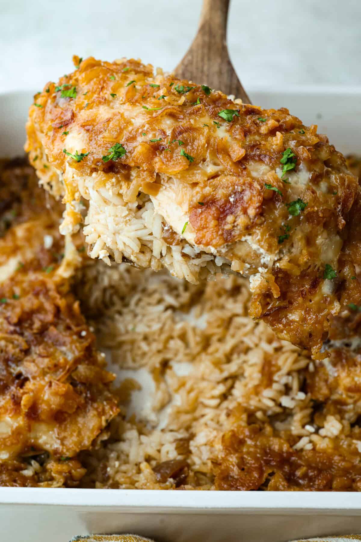 French onion chicken and rice casserole brings the rich, savory flavor of French onion soup to an easy, cheesy dinner. Tender chicken, fluffy rice, melty provolone, and crispy fried onions all come together in one pan with just 10 minutes of prep. Close up of the French onion chicken and rice casserole.