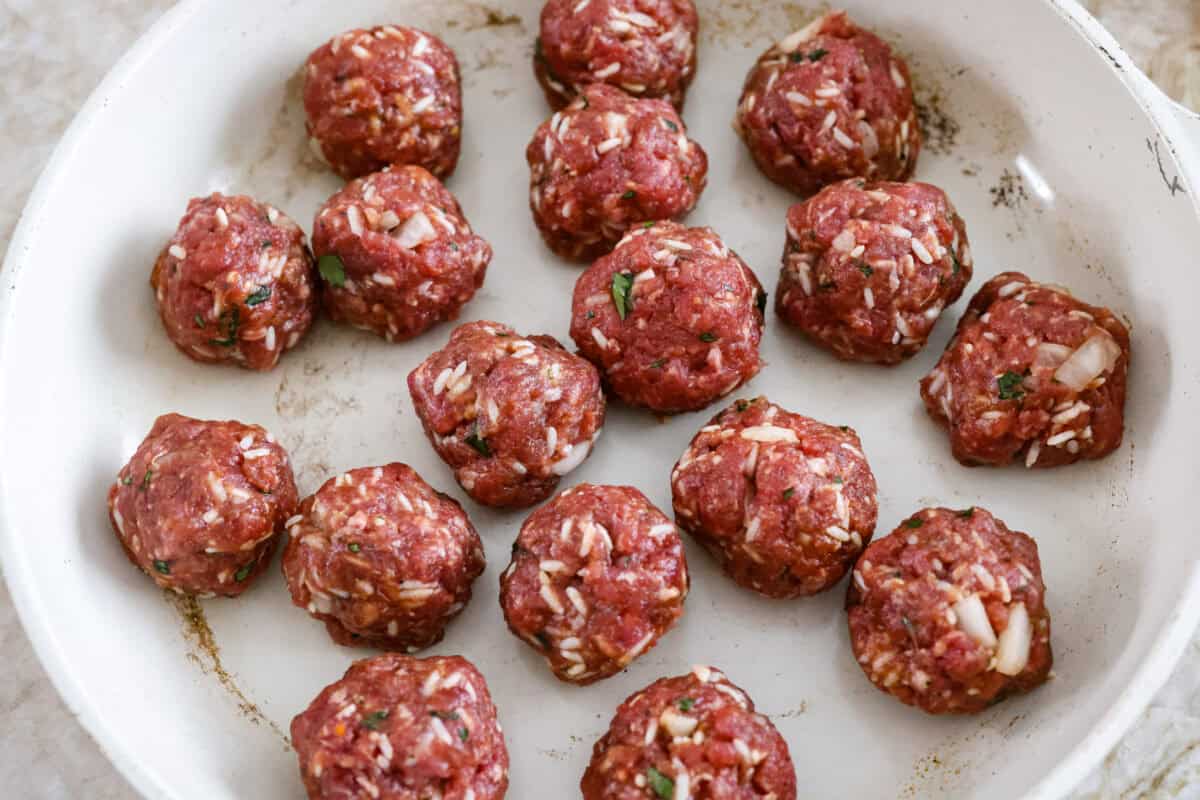 Porcupine Meatballs are juicy, well-seasoned meatballs with tender rice simmered in a rich, tangy tomato sauce. This recipe comes straight from my grandma’s kitchen, and trust me, your family’s about to be obsessed! Meatballs shaped in in a skillet.