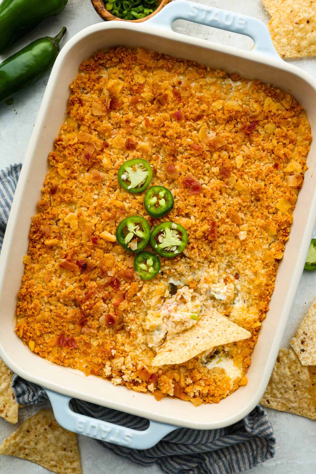 If you love jalapeño poppers, you need this dip. It’s creamy, cheesy, loaded with bacon, and topped with buttery Ritz crackers. Best of all, it takes just 10 minutes to prep, and is perfect for game day! Overhead shot of the baked jalapeño popper dip.