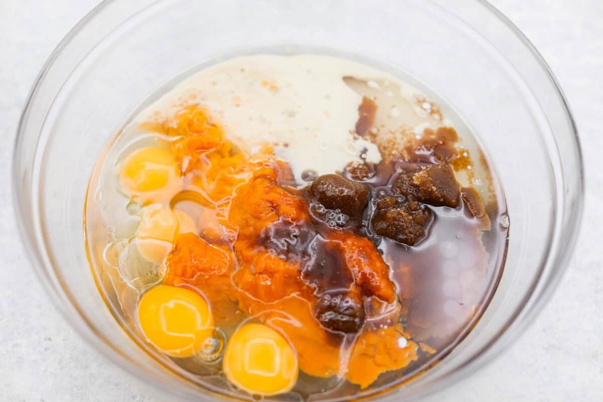 Pumpkin Sheet Cake Bars are one of my oldest son’s favorite desserts, and honestly, I get it! They’re incredibly moist and fluffy, full of warm pumpkin spice, and topped with the best cream cheese frosting. Wet pumpkin sheet cake ingredients added to a mixing bowl.