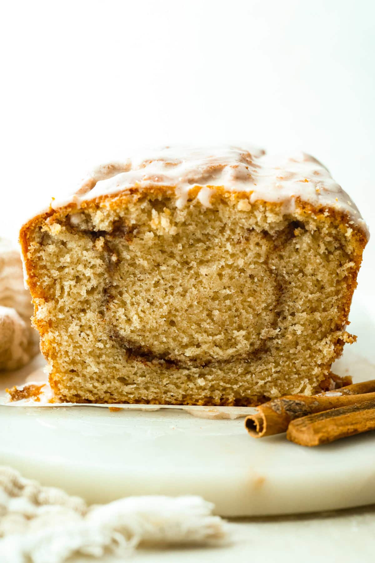 This snickerdoodle donut loaf is a fun twist on the classic cookie! It’s soft, tender, and packed with cinnamon sugar flavor, then finished with a sweet vanilla glaze. Think snickerdoodle meets cake donut in an easy-to-slice loaf! Side shot of snickerdoodle donut loaf.