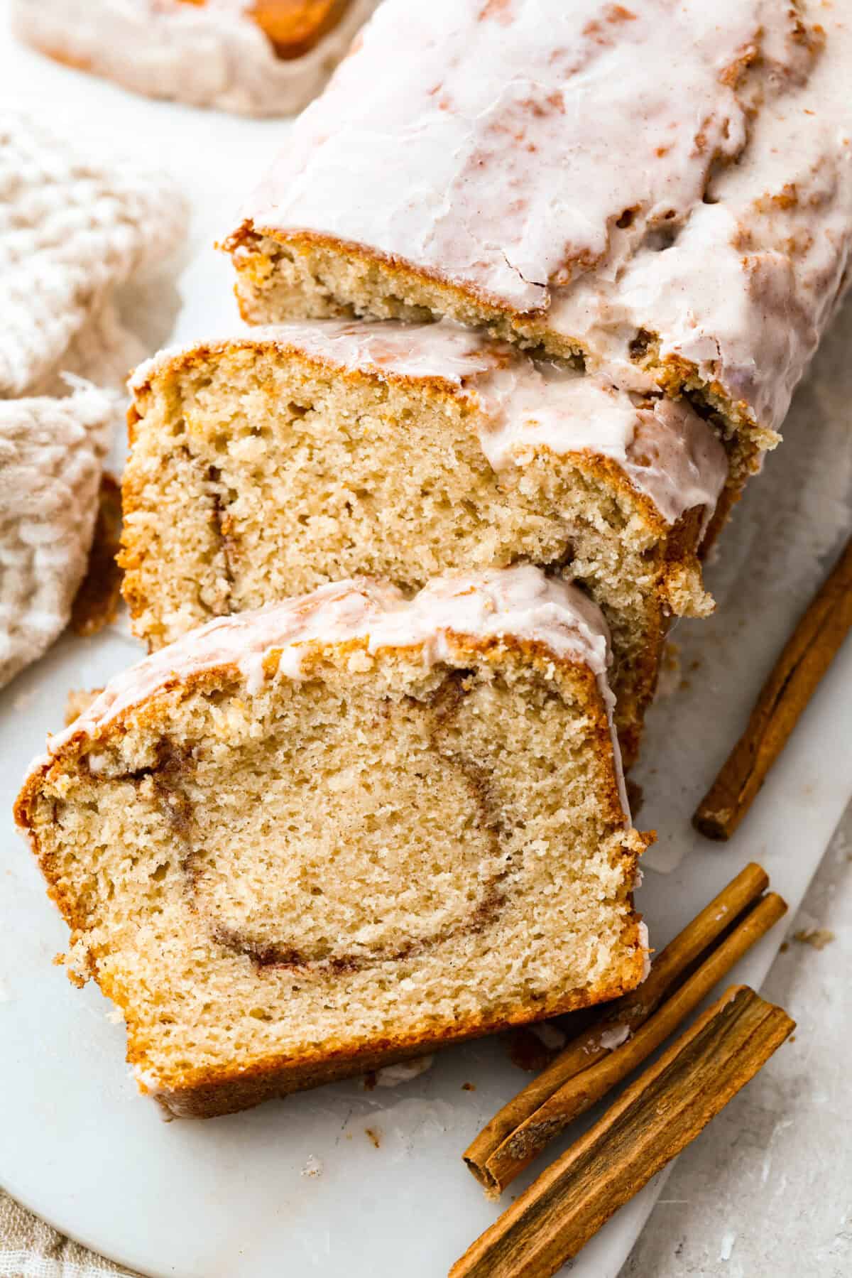 This snickerdoodle donut loaf is a fun twist on the classic cookie! It’s soft, tender, and packed with cinnamon sugar flavor, then finished with a sweet vanilla glaze. Think snickerdoodle meets cake donut in an easy-to-slice loaf! Snickerdoodle donut loaf with a couple of slices taken out of it.