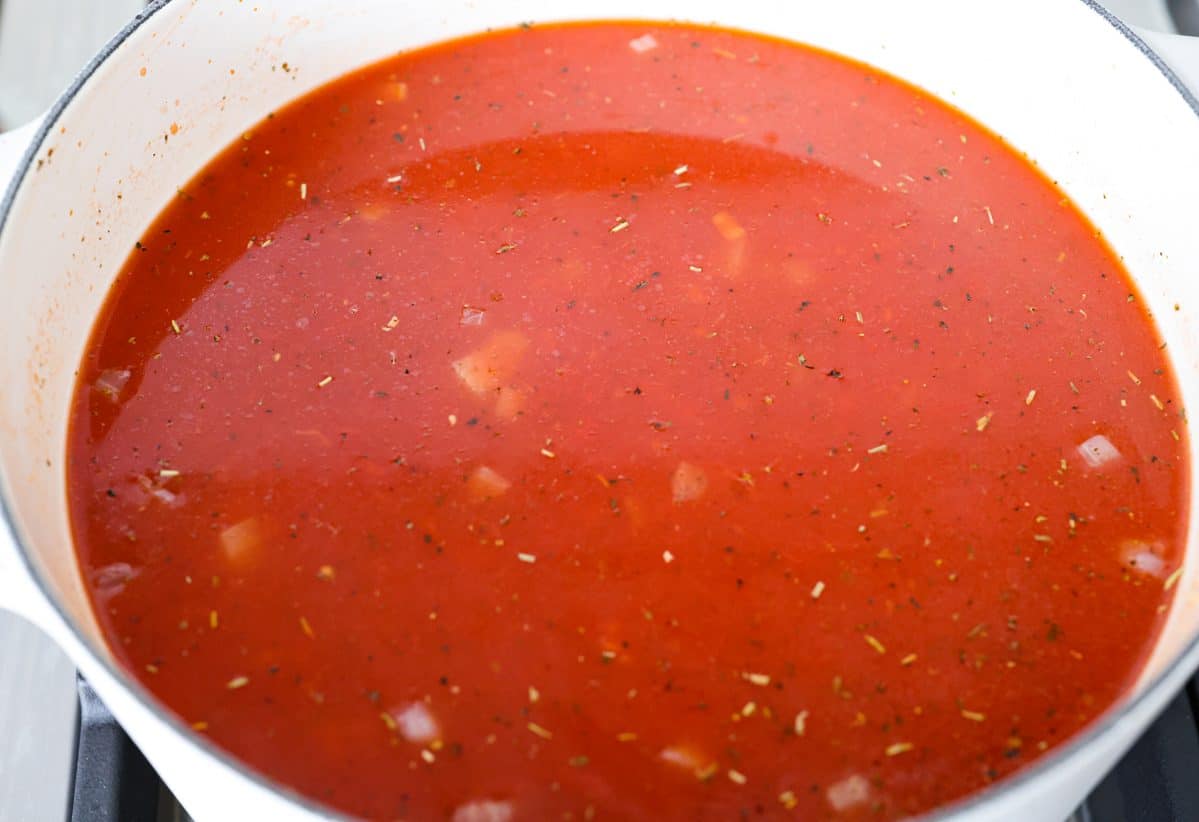 Craving chicken parm? Grab a spoon! This chicken parmesan soup is loaded with tender chicken, pasta, and a rich, creamy tomato broth. Finish with crispy, buttery breadcrumbs for a delicious twist on the Italian classic! Crushed tomatoes and tomatoes sauce added to the pot with the onion mixture.