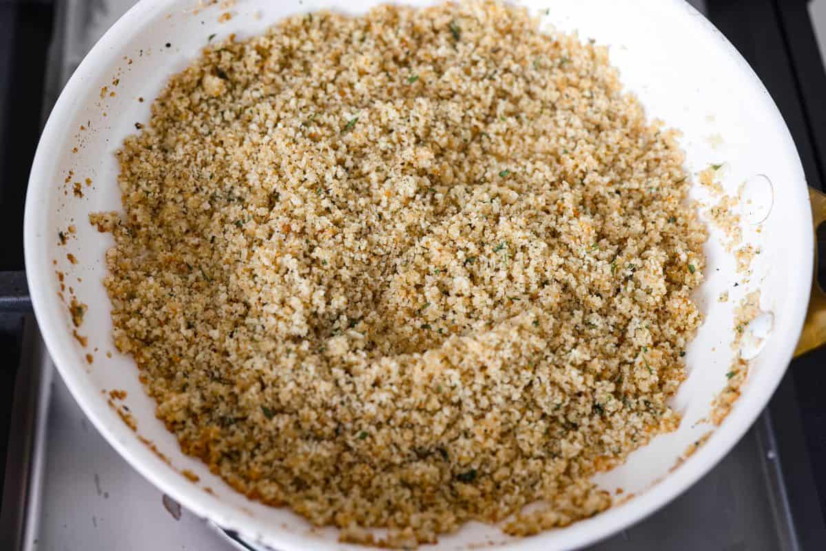 Craving chicken parm? Grab a spoon! This chicken parmesan soup is loaded with tender chicken, pasta, and a rich, creamy tomato broth. Finish with crispy, buttery breadcrumbs for a delicious twist on the Italian classic! Breadcrumbs added to the melted butter in the pan.
