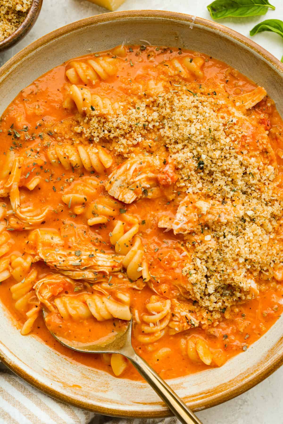Craving chicken parm? Grab a spoon! This chicken parmesan soup is loaded with tender chicken, pasta, and a rich, creamy tomato broth. Finish with crispy, buttery breadcrumbs for a delicious twist on the Italian classic! Bowl of chicken parmesan sou with crispy breadcrumb topping.