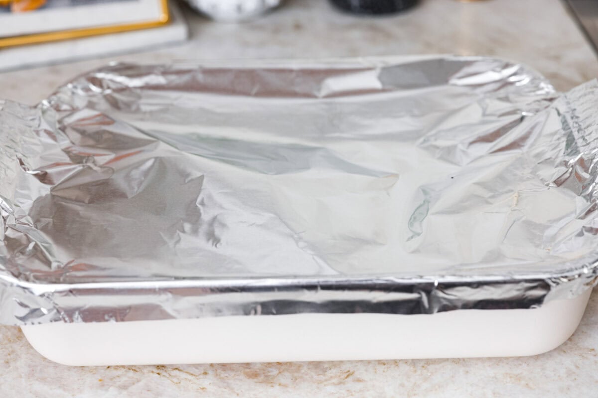 I LOVE fried rice, and my classic fried rice is already so easy, but I’m obsessed with this baked version! Dump everything into one baking dish, pop it in the oven, and dinner is served. It has all that savory fried rice flavor with less work! Broth, rice and veggie mixture all covered with foil, ready to go into the oven.
