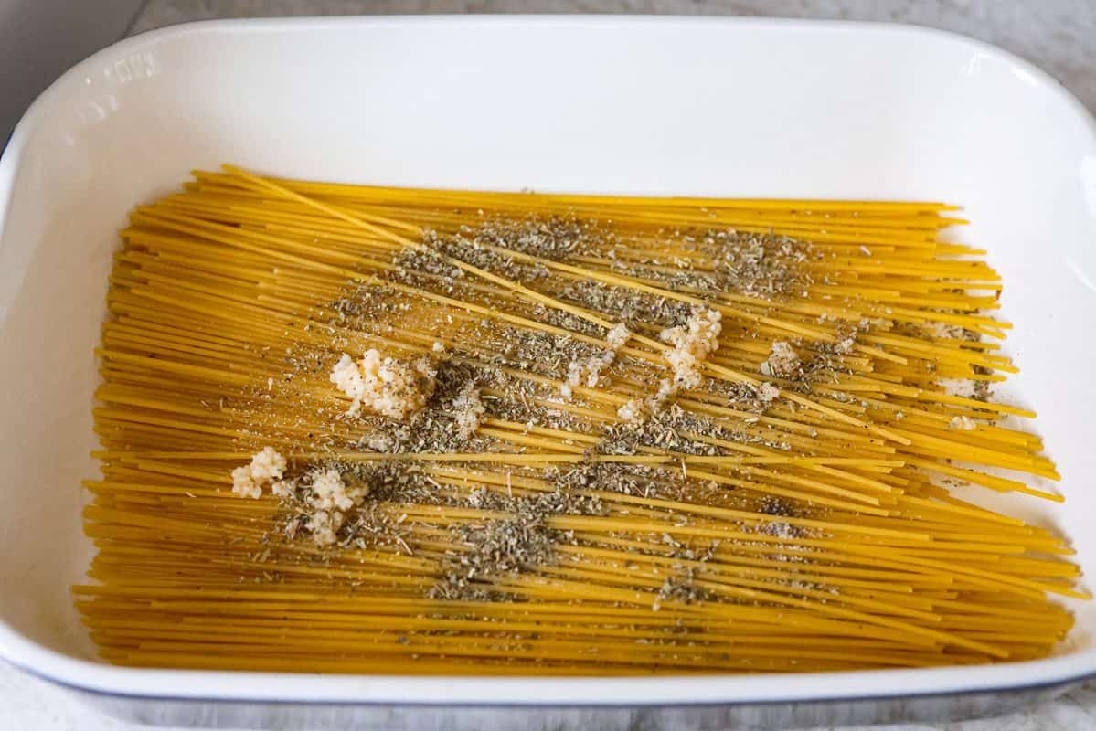 This no boil spaghetti bake makes pasta night SO easy! Everything goes straight into one baking dish, uncooked spaghetti included, then bakes under a layer of melty mozzarella for a cozy, cheesy dinner with hardly any prep. Spaghetti, seasonings in the bottom of the baking dish.