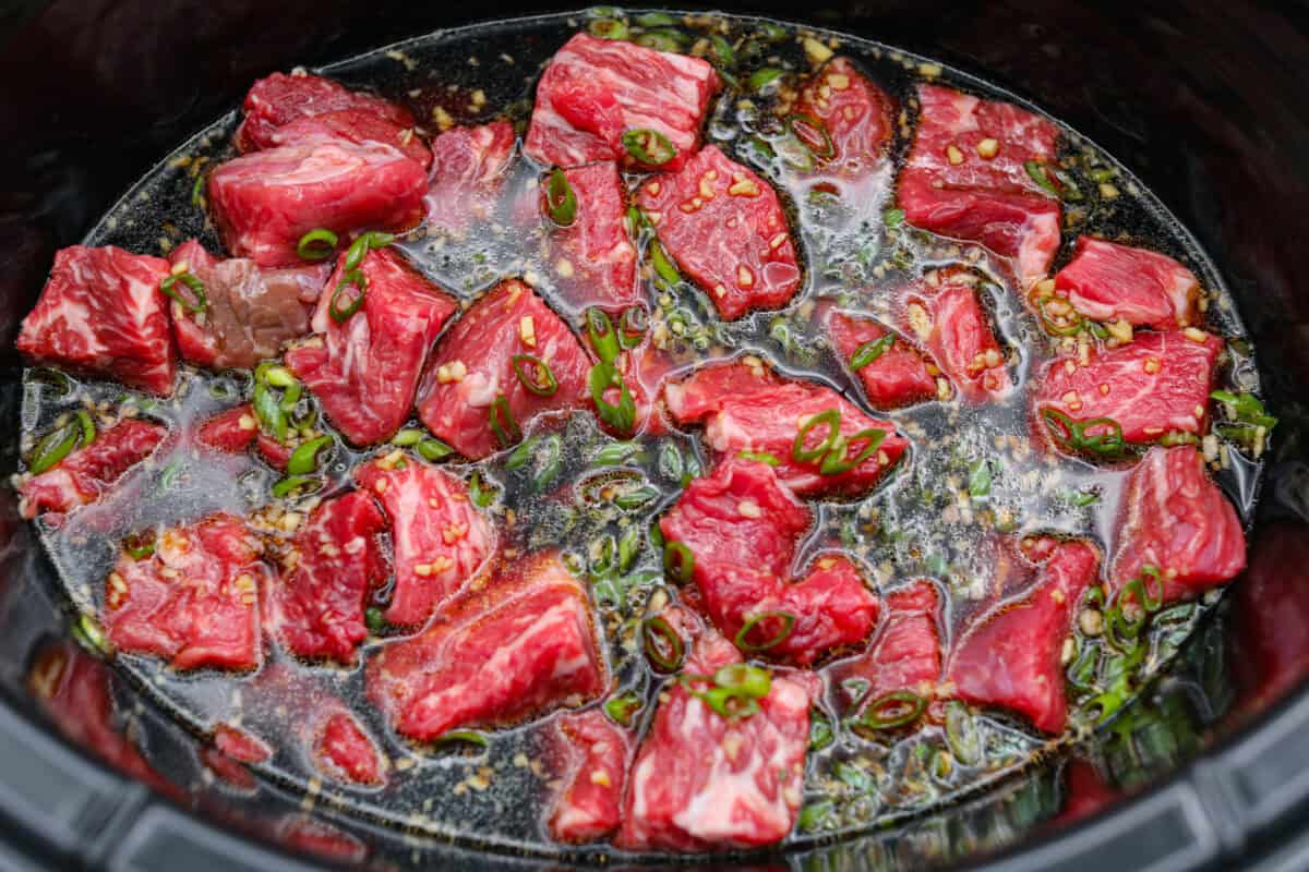 I love a good takeout-inspired dinner, especially when my slow cooker does most of the work! My slow cooker sesame ginger beef is packed with sweet and savory flavor, and the chuck roast cooks until it's perfectly tender. Sauce poured over the beef chunks in the slow cooker.