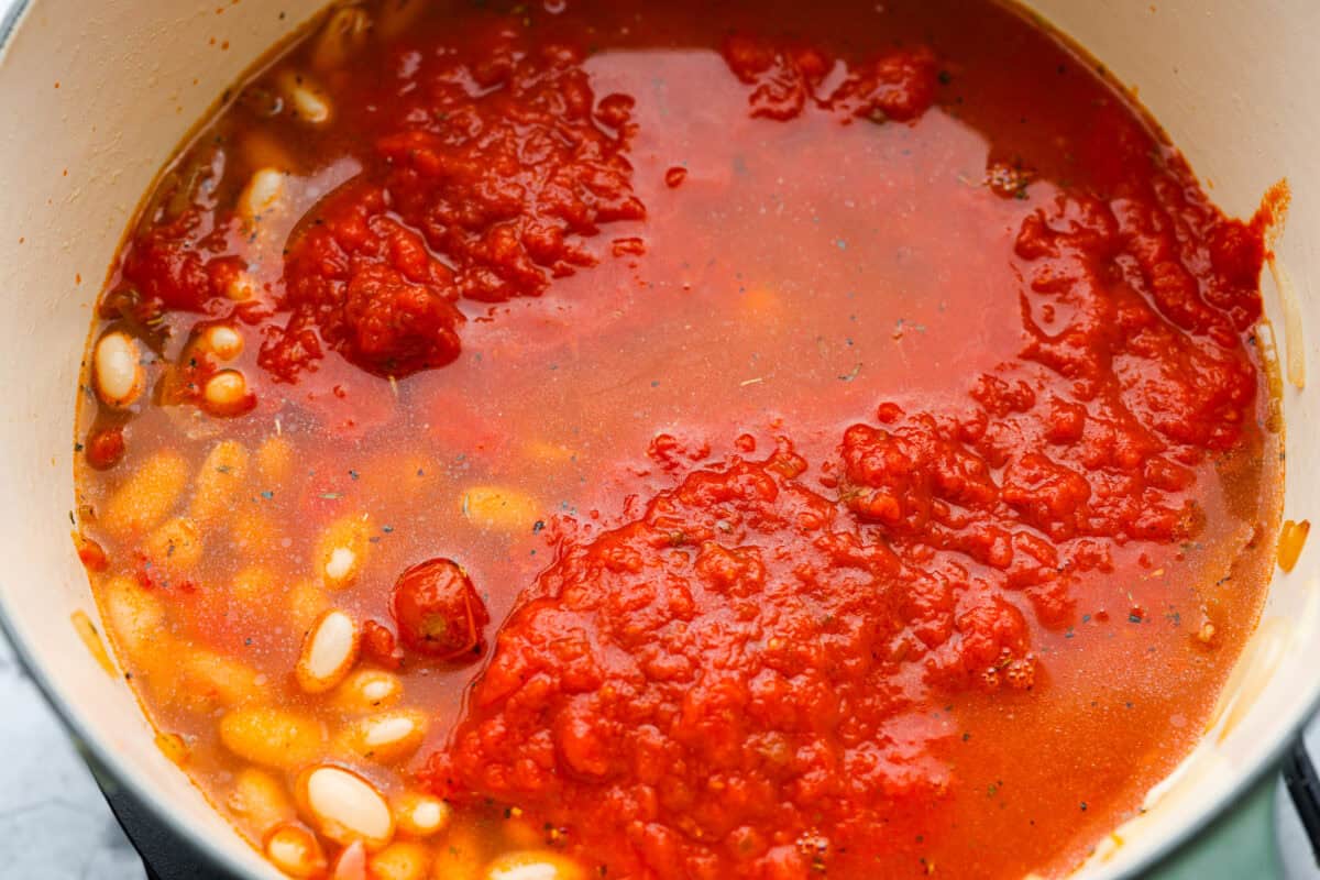 Beans, marinara sauce, and chicken broth added to the pot. 