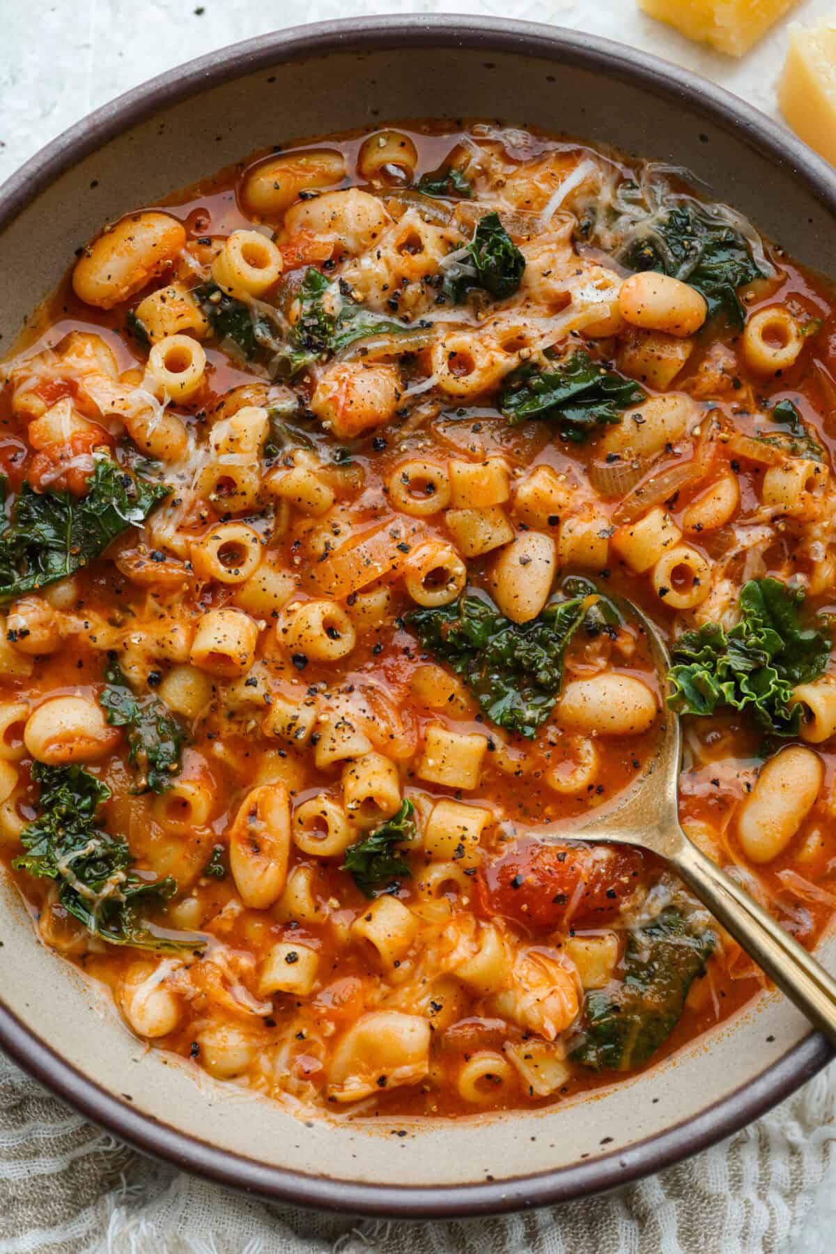 Serving bowl of Stanley Tucci Pasta Fagioli topped with parmesan cheese. 